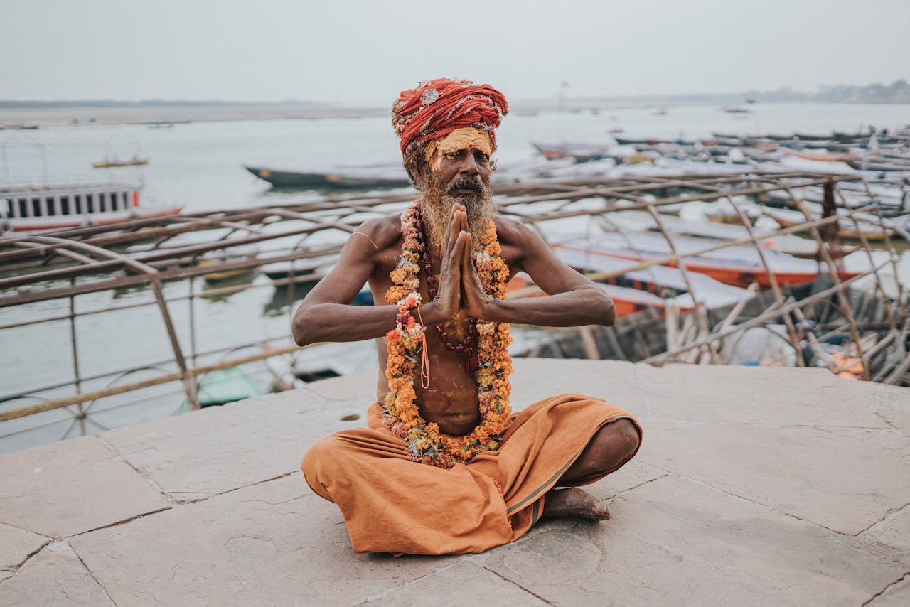 how-it-works A spiritual Sadhu meditating by the Ganges River in Varanasi, India. Captivating cultural scene.
